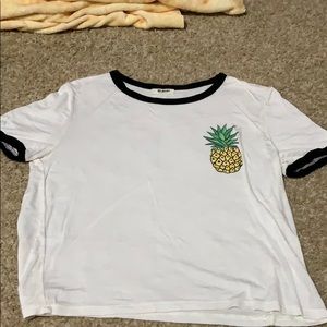 White tee with pineapple design on top left